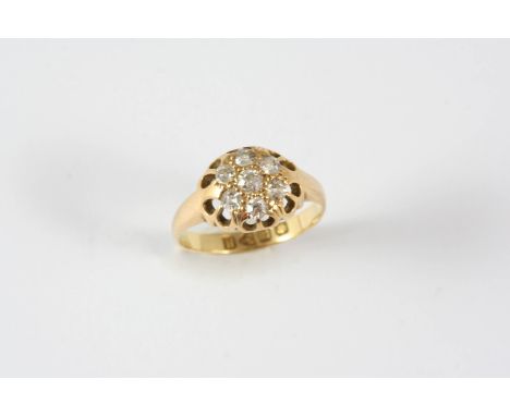 A DIAMOND CLUSTER RING mounted with seven circular old-cut diamonds, in 18ct. gold. Size K.