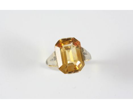 A CITRINE SINGLE STONE RING the emerald-cut citrine is set in gold, with platinum shoulders. Size K.