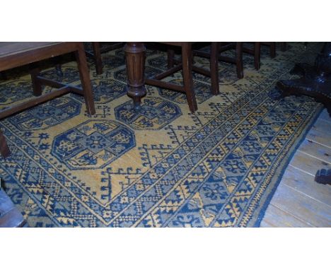 A Carpet in the Persian Style; with gold coloured ground and geometric medallion detail in borders of black and grey, 460 x 2