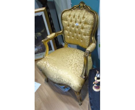 A Continental Gilt and Upholstered Armchair, having a  foliate carved and scroll top rail above a button upholstered back and