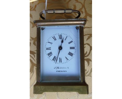 A French Brass Cased Carriage Clock; the white enamel dial with Roman numerals.