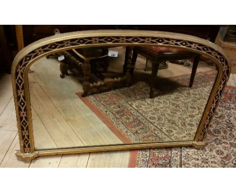 A Victorian Gilt Framed Overmantel Mirror of Arched Form, with running stylised floral detail raised on white glazed ceramic 