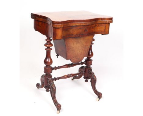 A Victorian walnut work table, the shaped rectangular fold-over top opening to reveal a games table for backgammon, chess and