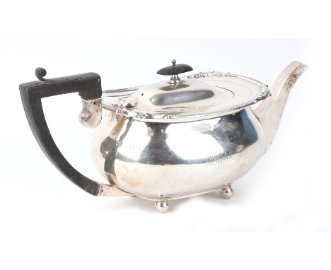 A George V silver teapot of compressed circular form, on bun feet, London 1920, 644g.