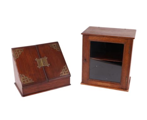 An Edwardian oak stationery box with fitted interior, 28cms wide; together with an oak table top display cabinet with single 