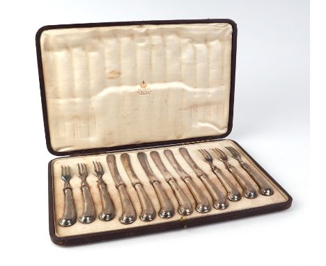 A set of six Edwardian fruit knives and forks with pistol grip handles, retailed by Asprey, Sheffield 1906, cased.