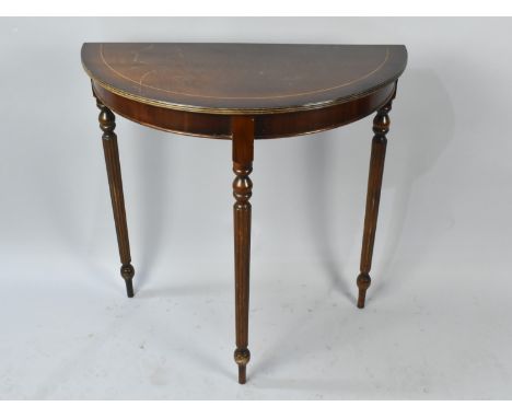 A Mahogany Demilune Console Table on Turned Reeded Supports, Top Somewhat Scratched, 75cms Wide