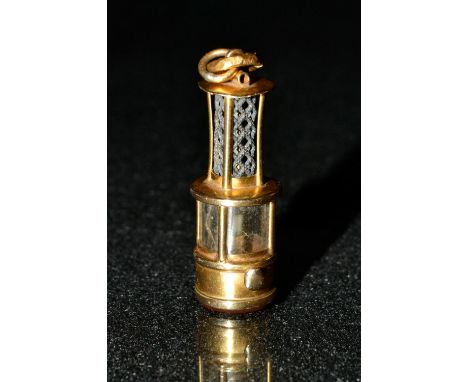 A miniature miners oil lamp seal fob, plain carnelian matrix, yellow gold body, silver grill, indistinctly marked, 35mm long,