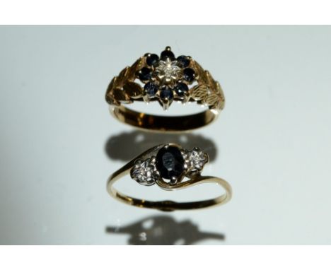 A diamond and sapphire trilogy ring, central dark blue oval cut sapphire flanked by a illusion set diamond accent to each sid