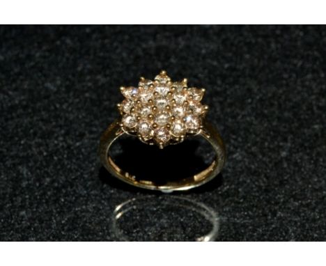 A Champagne/Cognac diamond cluster ring, pave encrusted with nineteen round cut diamonds arranged in a snowflake cluster pane