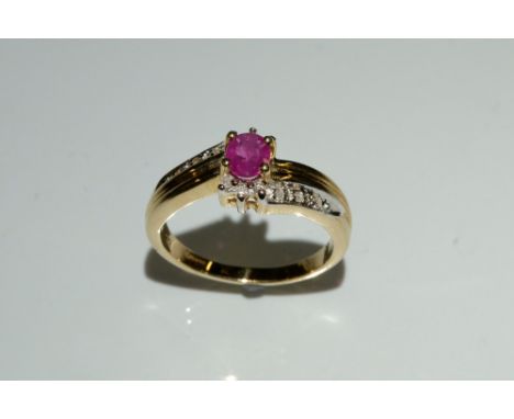 A ruby and diamond dress ring, central oval pinky red ruby, flanked by diamond encrusted mount and shoulders, inset with twel