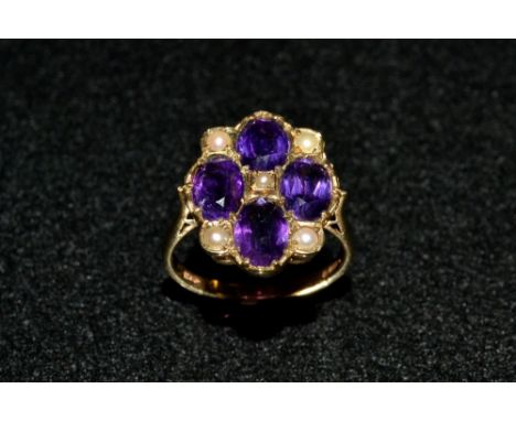 An Edwardian amethyst and seed pearl cluster ring,  inset with four oval vibrant purple amethysts and five seed pearls, 9ct g