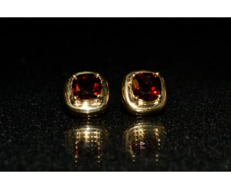 A pair of red garnet stud earrings, each with a single square cushion cut garnet, 9ct gold mount and pillars, stamped 375, 2.