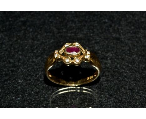 A ruby and diamond ring, central oval deep red ruby, collet set within an open mount encrusted with eight diamond accents, 18