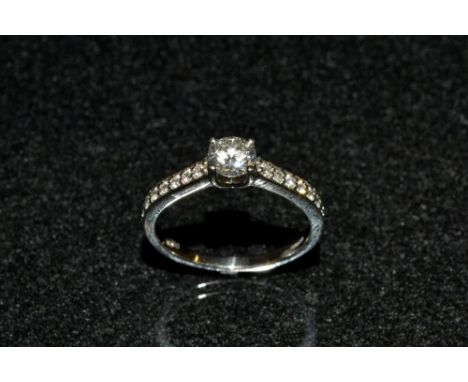 A diamond solitaire ring, round brilliant cut diamond approx 0.55ct, quarter claw set between seven stone diamond accented sh