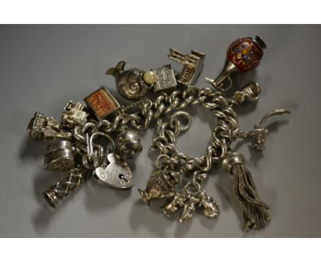 A silver curb link charm bracelet, suspending fifteen charms inc enamelled Ewer, Teapot, Cauldron, Lamp, Seal stamp, Boxing g