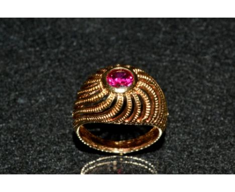 An 18ct gold Russian ring, arched open spiraling crest inset with a single round cut pale pink synthetic ruby,  measuring 5.8