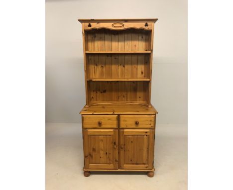 Modern Pine furniture, kitchen dresser, base with two door cupboard and twin drawers above, top with two shelves and pelmet t