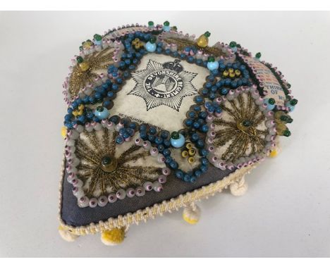 Militaria interest, WW1 Devonshire regiment sweetheart cushion of heart shape, decorated with beads fabrics and the regimenta