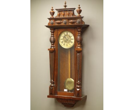 Late Victorian walnut cased Vienna type wall clock, cresting with turned finials, glaed door with fish-scale columns, circula