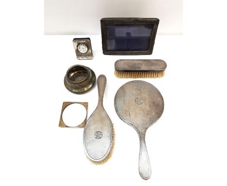 A silver dressing table set along with other items including, a silver desk clock and a silver picture frame. Various makers.