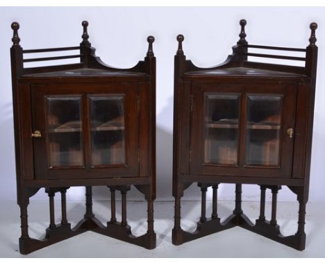 Pair of stained wood corner cabinets, each with two glazed panels to the doors, 66cms overall, together with a firescreen.