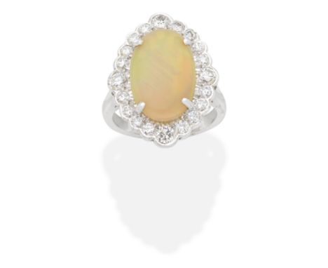 OPAL AND DIAMOND CLUSTER RING The oval opal cabochon within a brilliant-cut diamond surround, diamonds approx. 1.00ct total, 