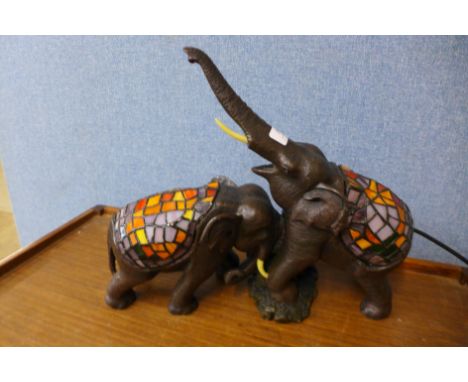 A figural elephant table lamp with Tiffany style shade