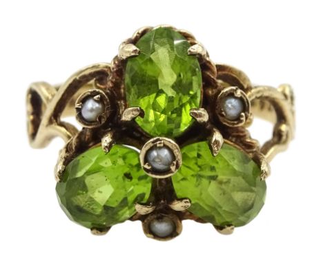 9ct gold three stone oval peridot and seed pearl ring, with open scroll design shoulders, London 1976Condition Report:Approx 