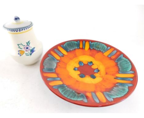 A Poole Delphis style dish, of circular form with flower head design on red ground, dolphin mark beneath, 26cm diameter, and 