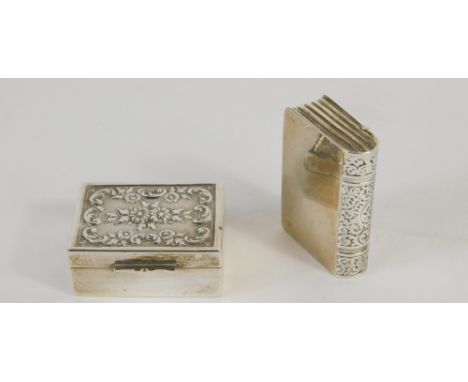 A novelty book shaped patch box, partially chased, marked 925, 3cm, and a further patch box, repousse decorated with flowers.