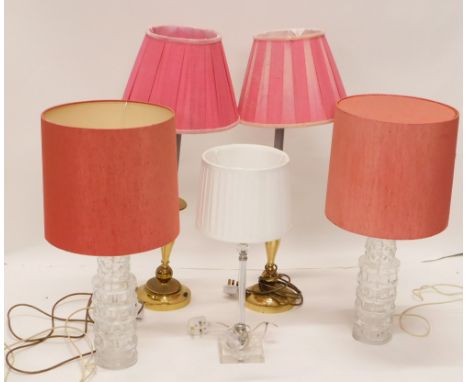 A pair of moulded glass bottle shaped table lamps, each with a red coloured shade, 62cm high, two brass effect table lamps (o