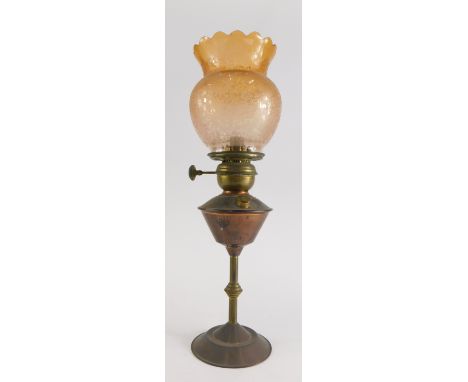 A late 19th/early 20thC copper and brass oil lamp, the orange tinted shade with edged decoration of flowers etc, the base of 