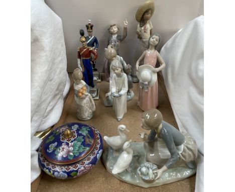 A collection of Lladro figures, including a girl on her knees feeding ducks, a matador, a girl holding a candle, a Nao figure