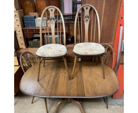 An Ercol extending dining table and four swan back chairs