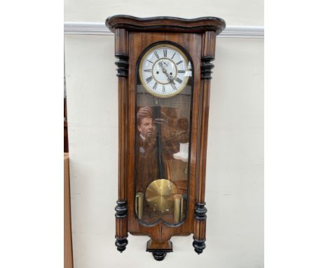 A Vienna regulator type wall clock, with a serpentine top and fluted columns with twin brass weights