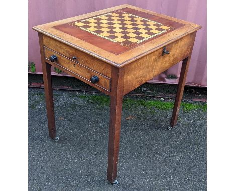 A George III mahogany games table, with reversible chessboard and backgammon top, a candle slide, a short drawer with bun sha