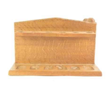 Robert Mouseman Thompson (1876-1955): An English Oak Pipe Rack, with six holders, shaped square back with carved mouse tradem