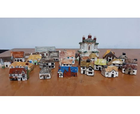 A collection of twenty eight collectable miniature ceramic and pottery hand painted houses, made in England, some minor chips