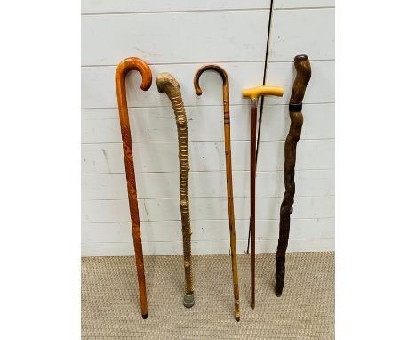 A selection of vintage walking sticks including a silver collared walking cane 