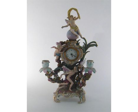 A rococo style mantel clock in the form of Old Father Time bearing a metal scythe on a base with four scroll feet surrounded 