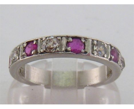 A ruby and diamond half hoop ring, composed of ten alternate old cuts and round cut rubies, the band 3.7mm wide, the white me