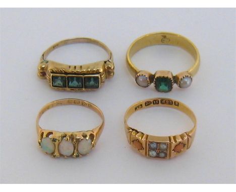 A mixed lot of four gem set rings, including a late Victorian three stone opal ring, the 18 carat gold shank fully hallmarked