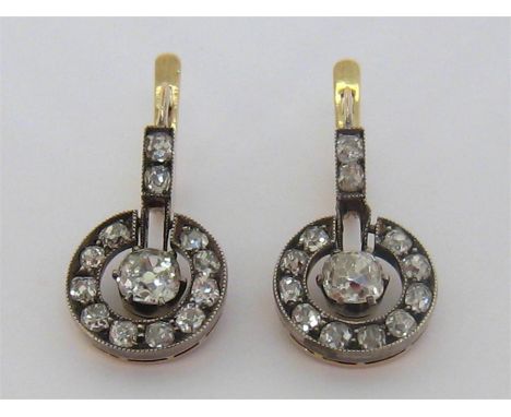 A pair of late 19th/early 20th century diamond drop earrings, each composed of a central cushion cut stone approx. 0.35 carat