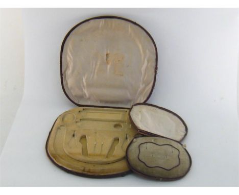 A vintage case for a parure, lined in oyster silk and deep cream velvet, also a tooled leather case to hold a suite of neckla