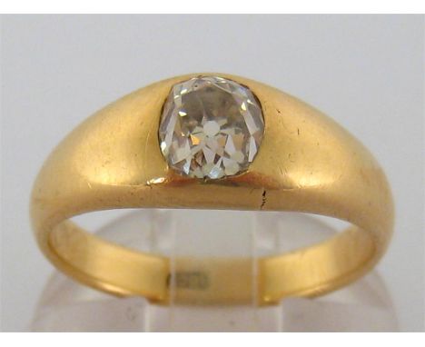 An 18 carat gold and single stone diamond ring, the central cushion cut diamond 5.85 x 5.2 x 4.45mm, open backed rub-over set