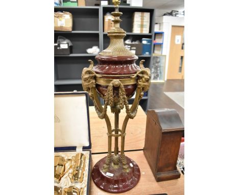 An impressive large Victorian style ceramic and brass lamp base, having Rams heads in brass interspersed with swags stood on 
