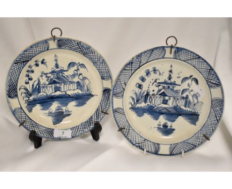 Two 18th century Delftware plates, having Oriental designs of pagodas and lakes.