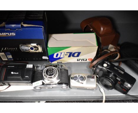 Four cameras. A Fuji DL10 Compact, and Olympus Stylus 410 Digital, a Canon Sureshot 105 and a Halina 35mm camera
