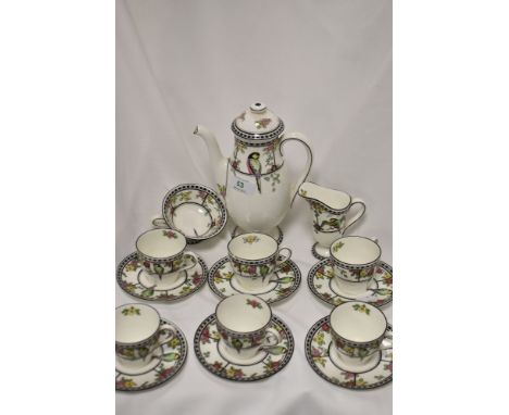 An Art Deco Royal Doulton partial coffee set, having vibrant flower and parrot transfer pattern, comprising six cups and sauc